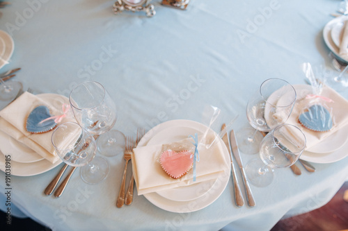White plates on blue tablecloth, pink and blue heart form cookies on plates