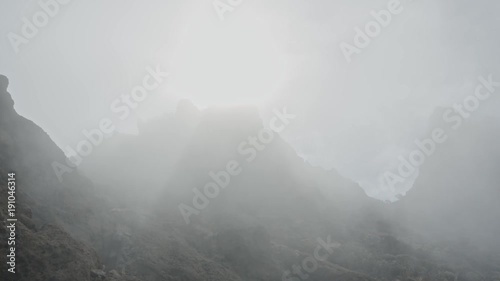 Very foggy cliff with lightrays coming through.