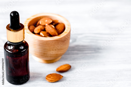 cosmetic almond oil in glass bottle on wooden background