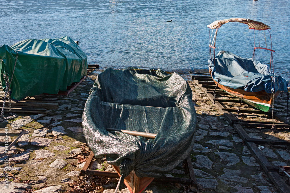 Historic wooden rowing boats moored on the shore of Lake Maggiore in Italy.