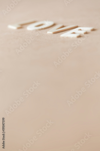 Valentine's day card with "LOVE" text on wooden background.Extreme close up and abstraction with selective focus and very shallow dept of field composition,sweet pastel color toned.