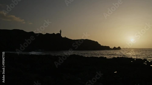 Sunset at rocky seashore.
