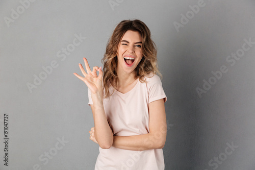 Woman in t-shirt showing ok sign while looking at camera