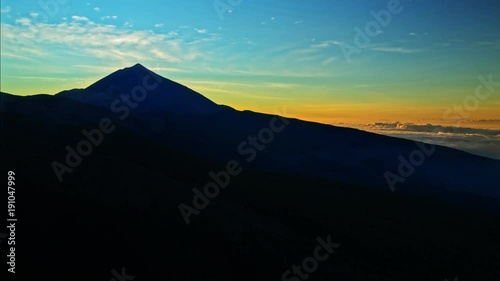 Time lapse of sunset behind vulcano Teide sourrounded by clouds.