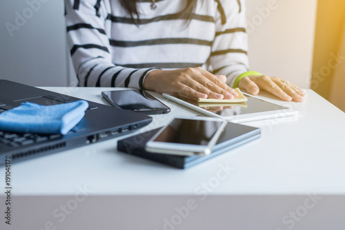 Hand woman cleaning her tablet on screen with microfiber cloth