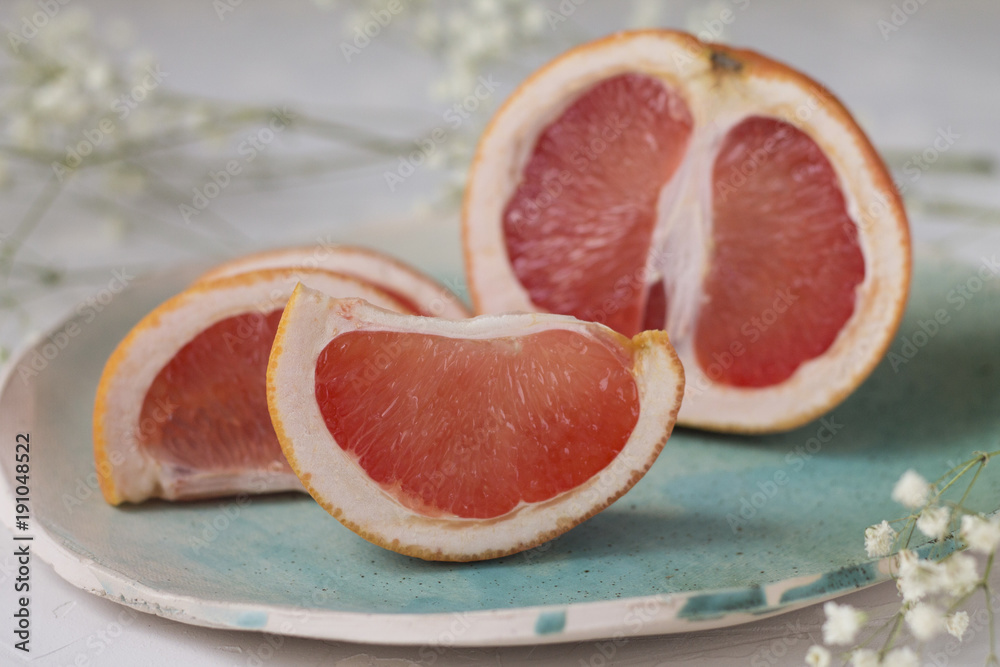 slices of juicy red grapefruit on blue green turquoise plate background texture slices of juicy red grapefruit on blue green turquoise plate background texture
