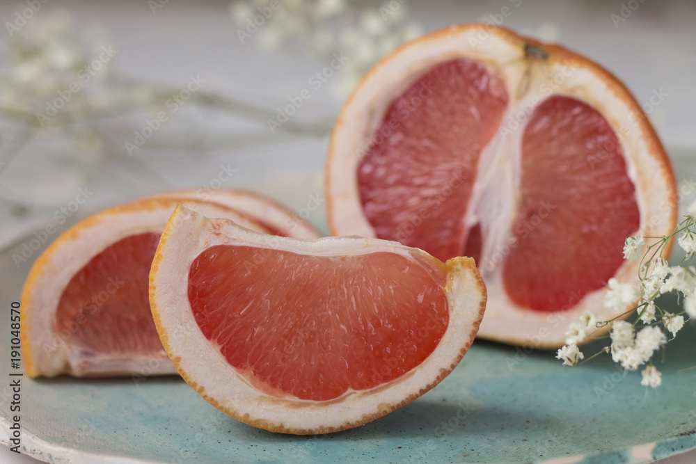 slices of juicy red grapefruit on blue green turquoise plate background texture slices of juicy red grapefruit on blue green turquoise plate background texture
