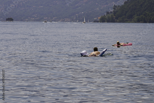 Photography A bather relaxes by floating with the inflatable mattress on the lake