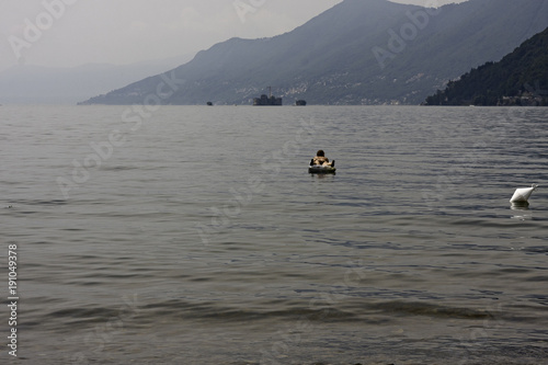 A bather relaxes by floating with the inflatable mattress on the lake.