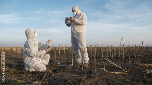 Slow motion footage of ecology specialists in white protection clothes observing and analyzing contaminated landscape, collecting soil samples