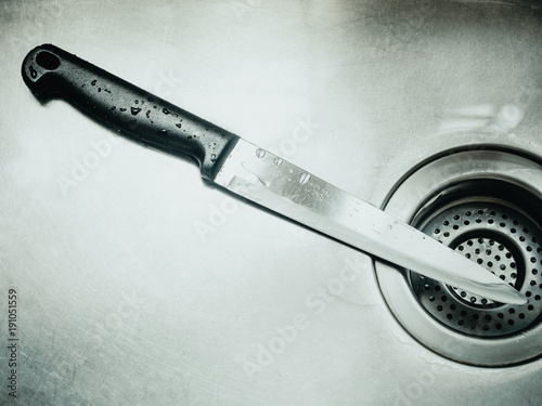 black handle stainless knife after clean and drop of water in sink with murder , horror concept background photo