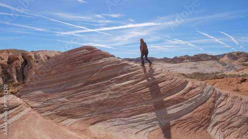 Sports Hiking Woman Climbs Up The Red Rock Background The Sky photo