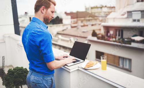 Business person using laptop on rooftop