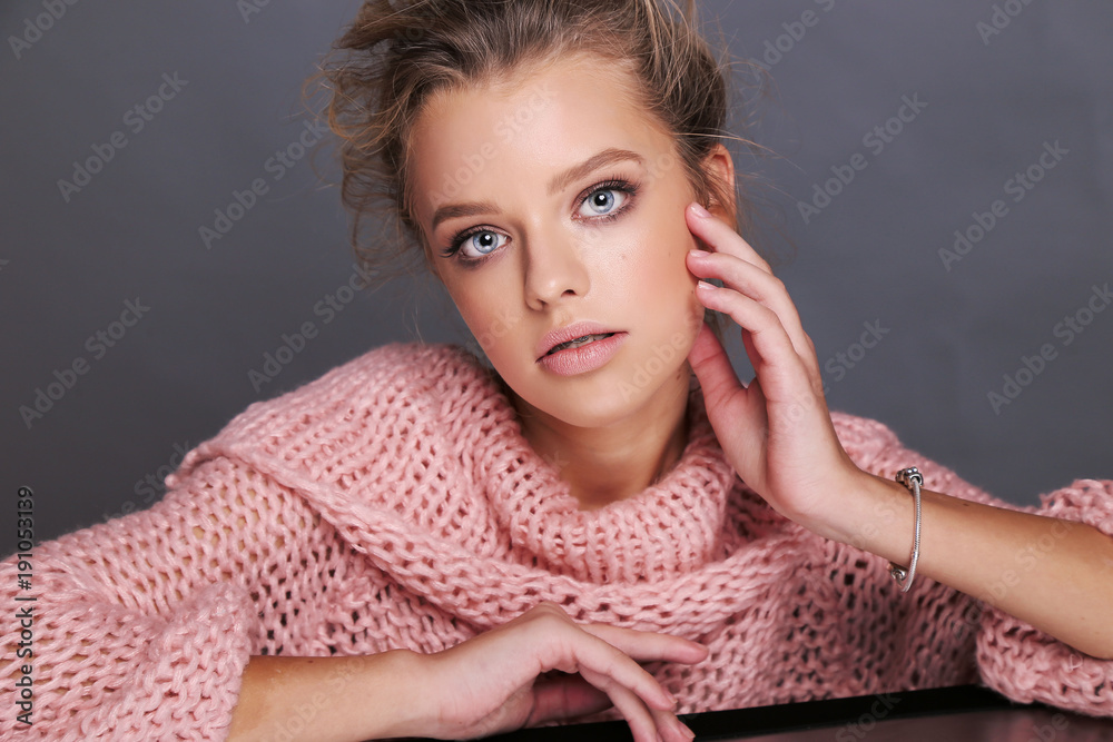 beautiful young girl with blond hair in cozy clothes posing in studio beautiful young girl with blond hair in cozy clothes posing in studio