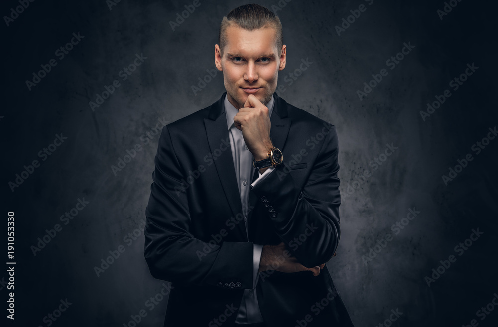Handsome businessman against a dark background. Handsome businessman against a dark background.