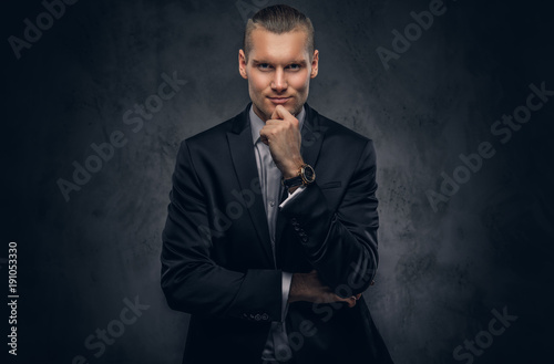 Handsome businessman against a dark background.