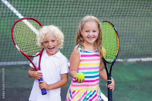 Children playing tennis on outdoor court