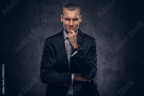 Handsome businessman against a dark background. © Fxquadro