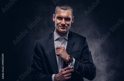 Handsome businessman against a dark background.