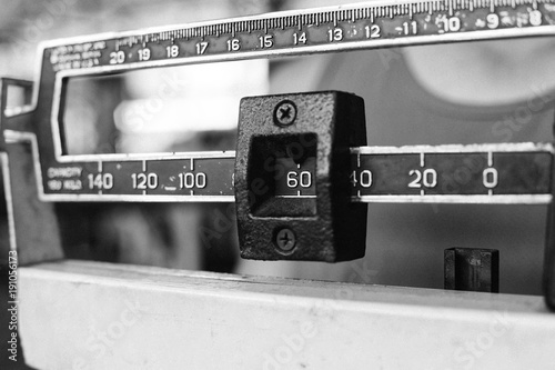 Sport man weighing himself on balance weight scale at the gym
