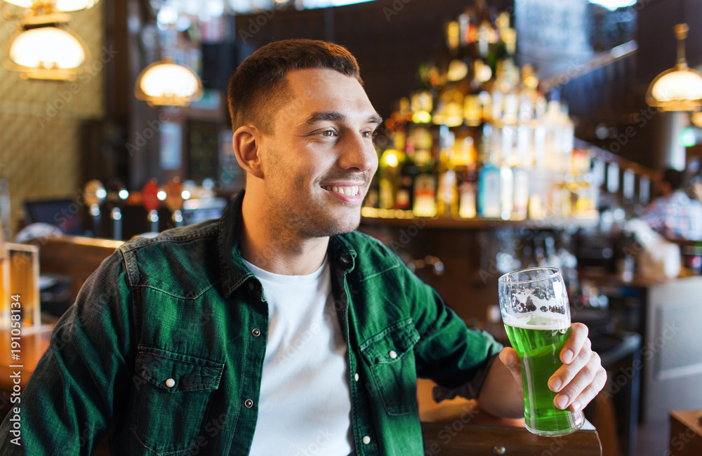 man drinking green beer at bar or pub man drinking green beer at bar or pub