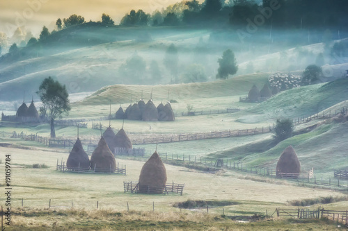 Beautiful rural mountain landscape in the sunrise light with morning fog, Fundatura Ponorului, Hunedoara County, Romania