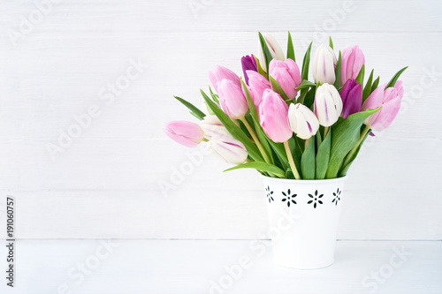 Fototapeta Naklejka Na Ścianę i Meble -  White and pink tulips bouquet in white vase on white background. Holiday background, copy space