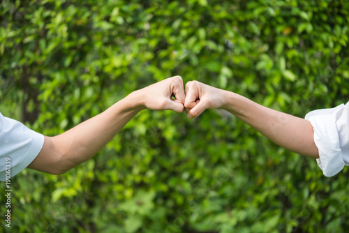 man and woman hand fist on green leave background © kwanchaift