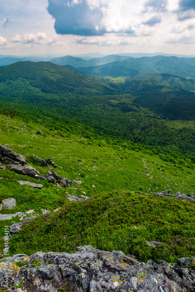 Fototapeta premium mountain behind the valley viewed from rocky cliff. beautiful summer landscape with grassy slopes under the cloudy sky. location mountain Pikui, TransCarpathia, Ukraine