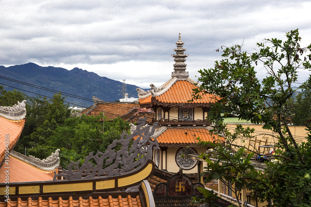 orange roof of the Buddhist pagoda with mountains on the background