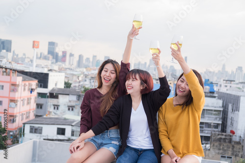 Canvas Print Group of asian friends drinking and having fun outdoor cheering at top roof