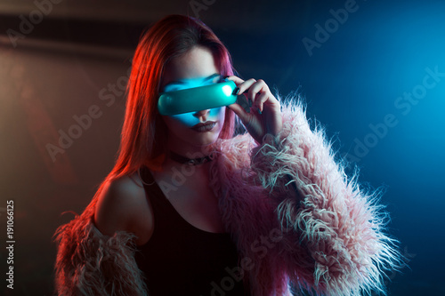 Beautiful young woman in futuristic glasses virtual reality, cyberpunk style, neon light © Ulia Koltyrina