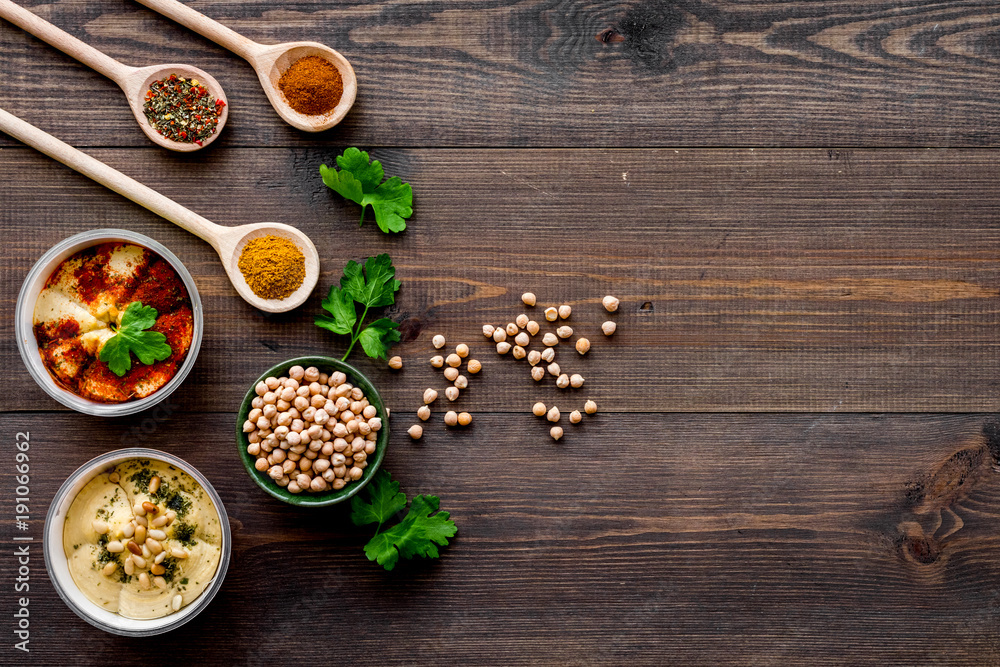 Cook chickpeas. Make hummus. Bowls with grains and ready meal near spices on dark wooden background top view copy space Cook chickpeas. Make hummus. Bowls with grains and ready meal near spices on dark wooden background top view copy space