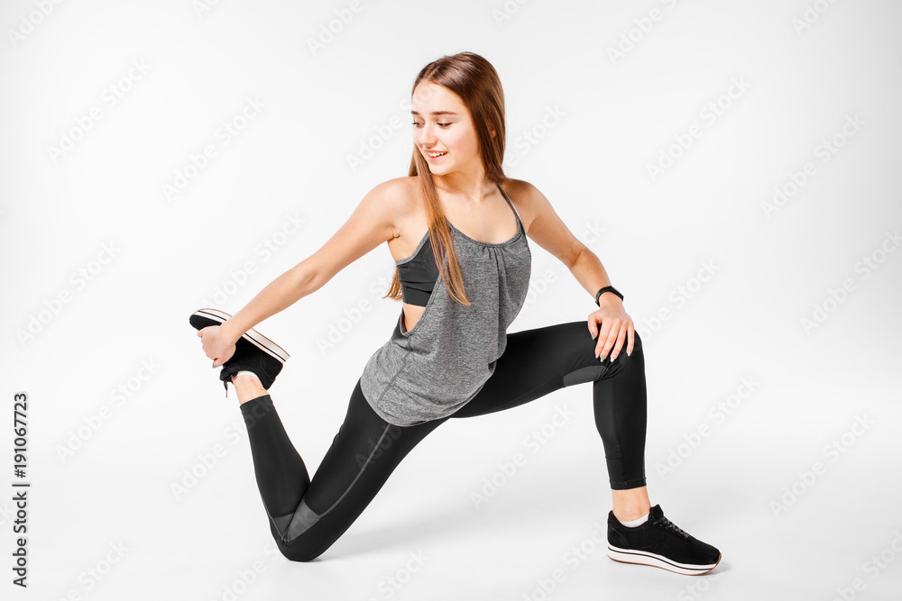 Young fit girl doing stretching isolated on white background.