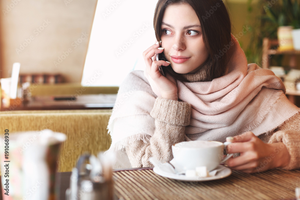 Beautiful young girl using phone in cafe Beautiful young girl using phone in cafe