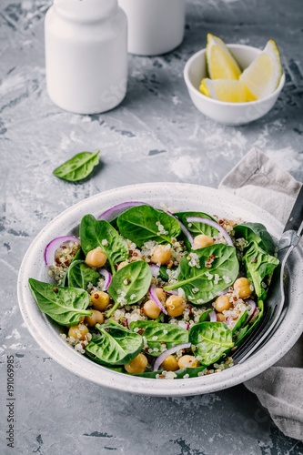 Healthy green salad bowl with spinach, quinoa, chickpeas and red onions