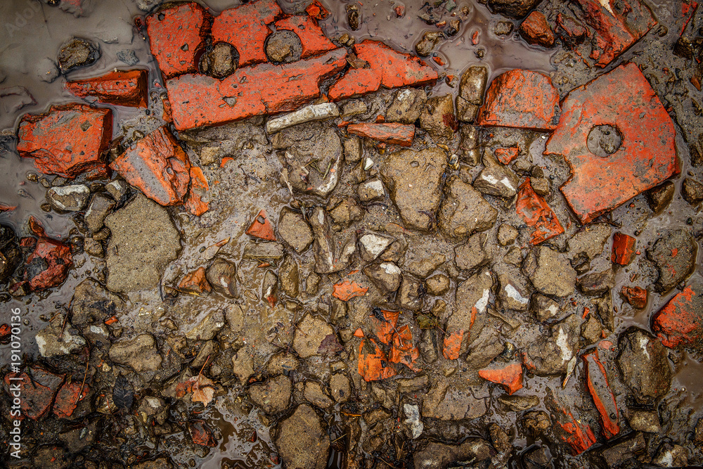 Broken bricks in a puddle. Pieces of plaster. Grunge background