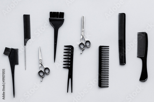 Beauty saloon equipment. Hairdress, haircut. Combs, sciccors, brushes on grey background top view
