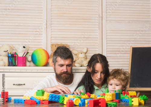 Parenthood concept. Family playing with colorful plastic blocks.