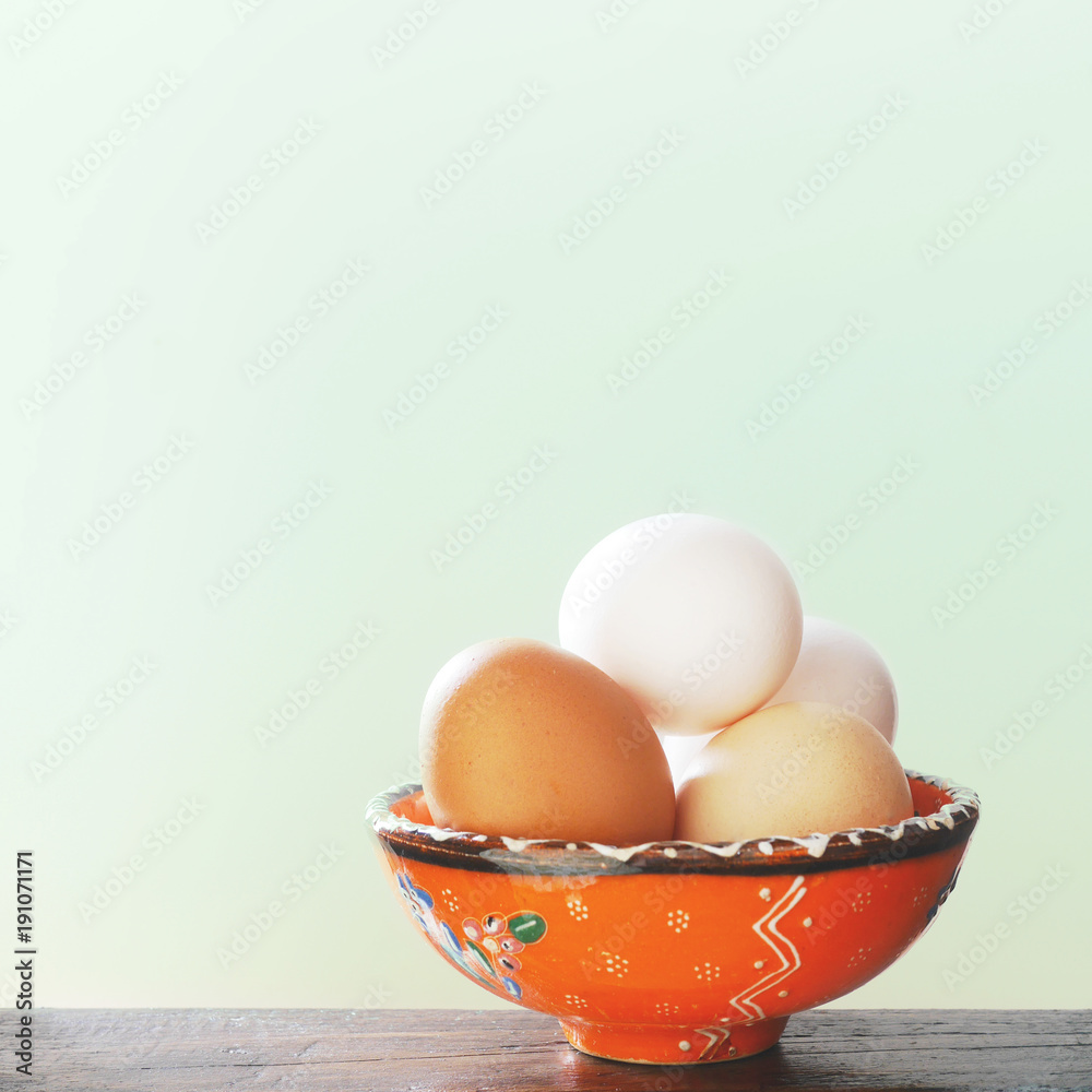 Easter eggs in a orange cup on a light green background. Easter eggs in a orange cup on a light green background.