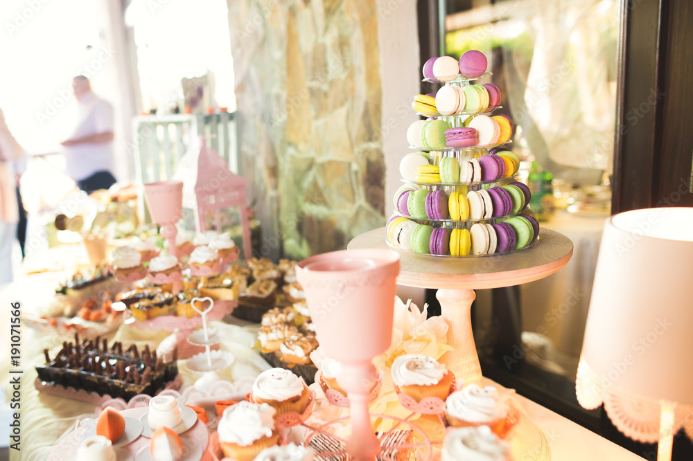 Delicious and tasty dessert table with cupcakes shots at reception closeup