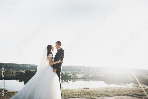 Wedding couple posing on sunset at wedding day. Bride and groom in love