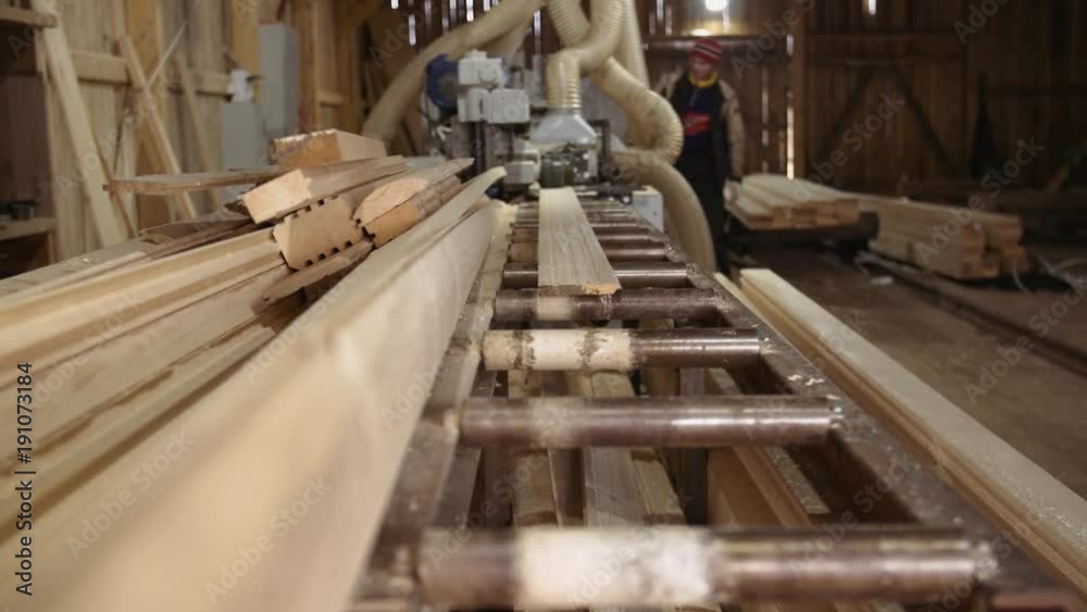 Wood board running out carpenter jointer workbench at sawmill facility, lots of sawdust Wood board running out carpenter jointer workbench at sawmill facility, lots of sawdust