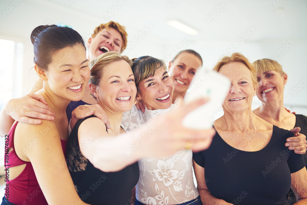 Laughing group of friends taking selfies in a dance class Laughing group of friends taking selfies in a dance class