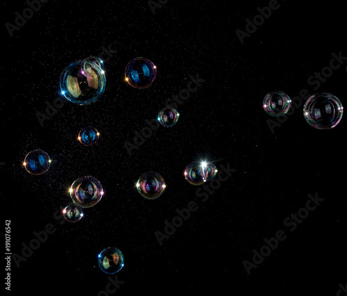 Foto Rainbow soap bubbles on black background.