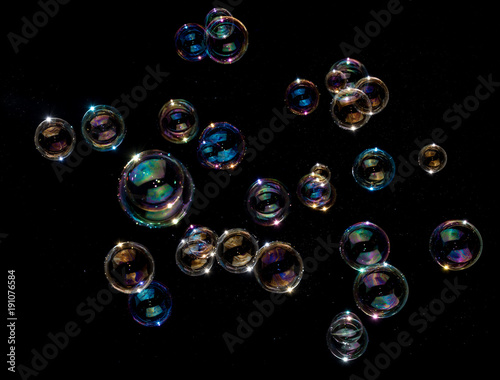 Rainbow soap bubbles on black background. photo