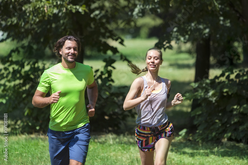 Young couple jogging at the green environment