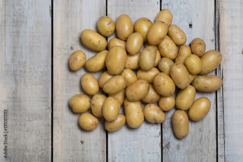 Raw baby potatoes on wooden background.