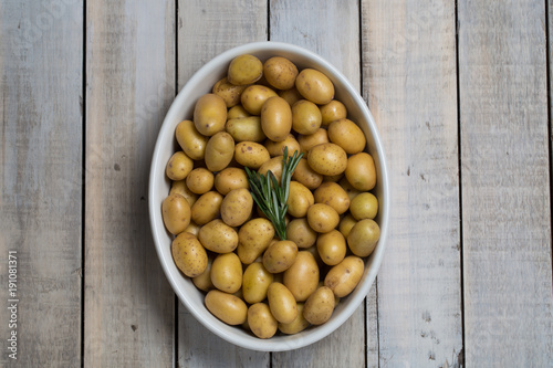 Raw baby potatoes in pan with rosemary, ready to cook in oven