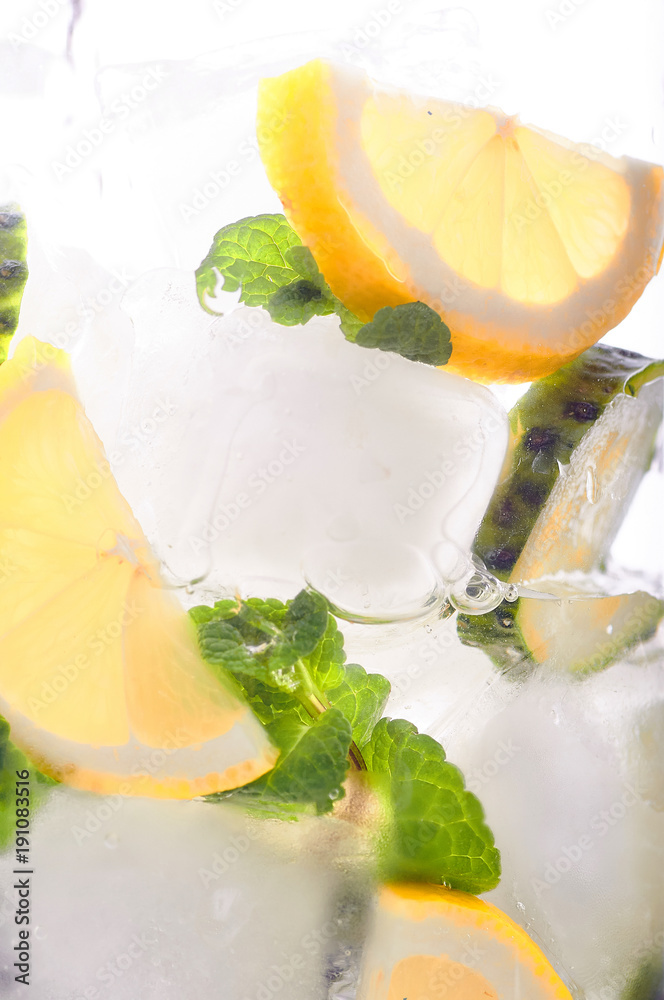 The main drink for detoxifying the body close-up. Alcoholic, nonalcoholic  drink with cucumber, mint, lemon, ice cubes. Ice mojito with water or  tonic. Morning drink for intensive weight loss. foto de Stock
